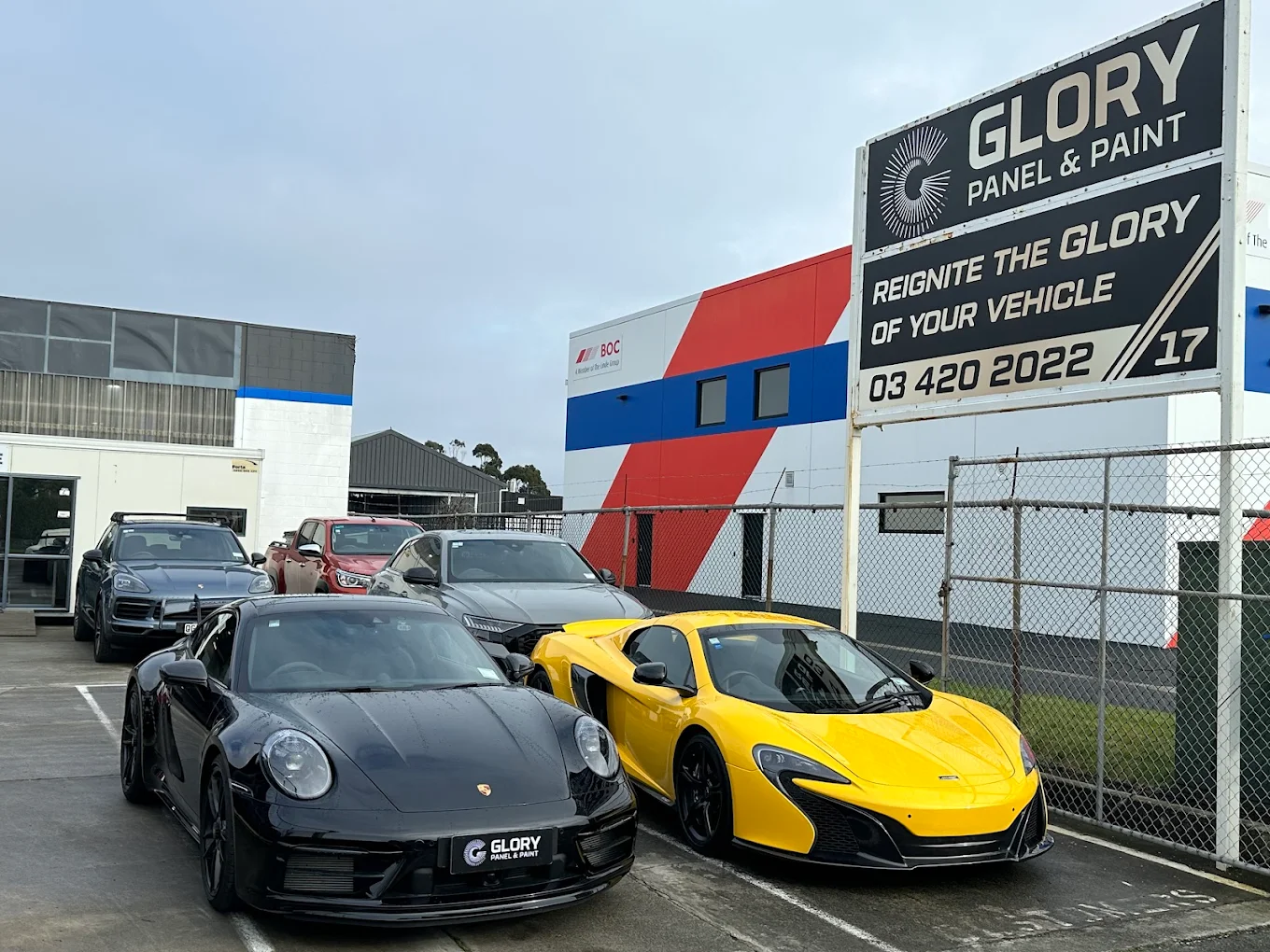Porsche 911 and yellow McLaren at GLORY Panel & Paint, Christchurch